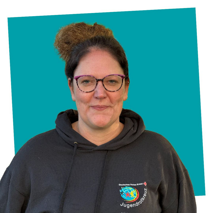 Porträt einer lächelnden Kontaktperson des Jugendrotkreuzes Niedersachsen in einem schwarzen JRK-Hoodie